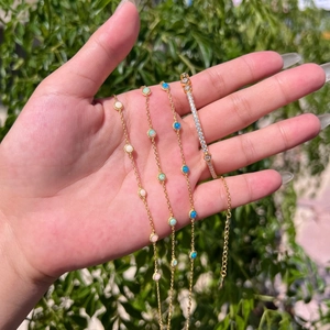 Detail showing S925 silver gold bracelets with opal stones and crystals on a hand