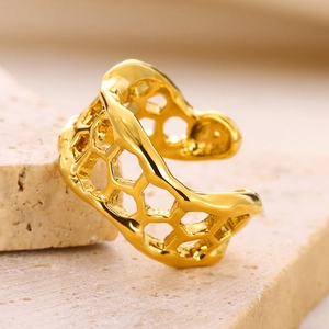 Macro shot of gold textured irregular ring with hollow honeycomb design on stone
