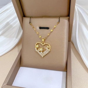 Elegant gold heart pendant necklace with star details and cubic zirconia in a jewelry box