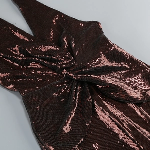 Detail of sequined bronze jumpsuit featuring a deep V-neckline and twist knot design