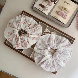 Detail of floral and polka dot cotton scrunchies displayed in a wooden tray