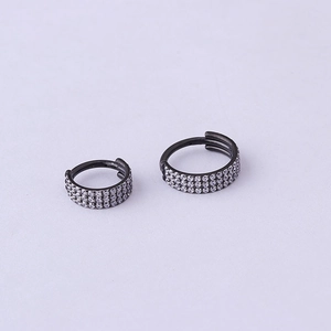 Detail view of black stainless steel hoop earrings with three rows of cubic zirconia stones