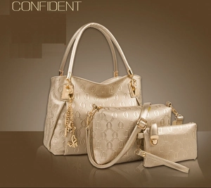 Detailed view of 3-piece champagne gold embossed tote bag set with metal butterfly charm