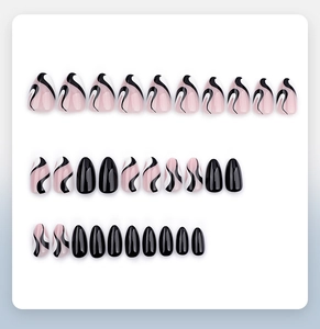 Close-up of pink almond press-on nails with black abstract fluid lines and solid black tips