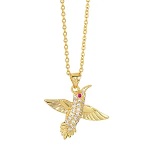 Minimalist golden hummingbird pendant necklace with white crystals and red gem eye