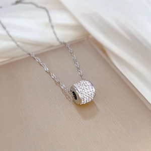 Macro shot of titanium steel necklace pendant with micro-pave crystals on textured surface