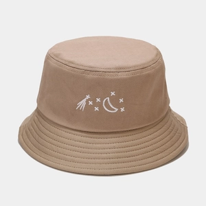 Detail of white star and moon embroidery on khaki canvas bucket hat with stitched brim