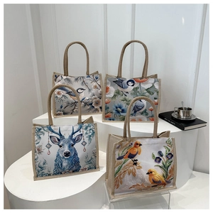 Detailed view of linen tote bags featuring vintage floral and blue elk patterns