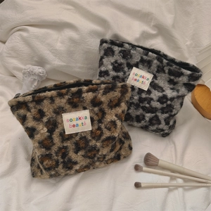 Detail of plush leopard print makeup bags with zipper closure and sozakka logo label