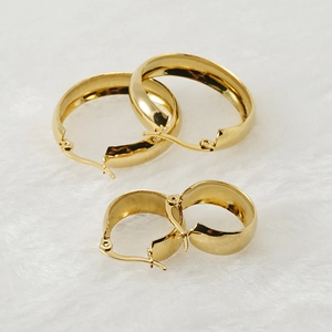 Polished 18K gold stainless steel chunky hoop earrings set on white soft fur background