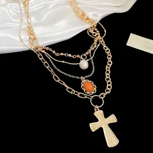Multi-layer gold necklace with cross pendant, pearl and amber gemstone on black silk
