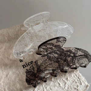 Close-up of elegant lace pattern hair claws in black and white translucent resin