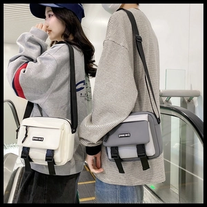 Detail of canvas messenger bags with buckle straps shown in a city lifestyle setting