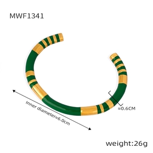 Detail view of gold-plated bangle with green enamel showing 6.0cm inner diameter