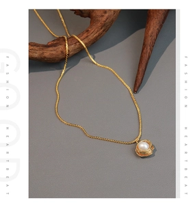 Detail of freshwater pearl pendant in gold bird nest design on elegant branch