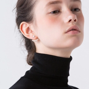 Gros plan de boucles d'oreilles éventail en perles et or 18 carats sur un mannequin