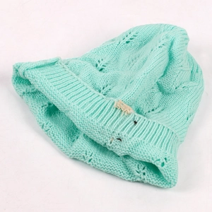 Detailed close-up view of a turquoise women's knitted beanie with leaf pattern