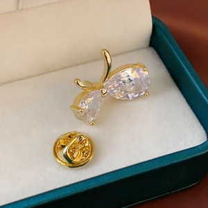 Détail macro d'une broche papillon dorée avec zircones étincelants sur écrin à bijoux