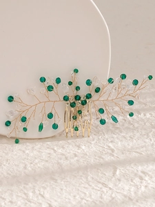 Macro detail of handmade gold leaf hair comb with green crystals and rhinestone beads