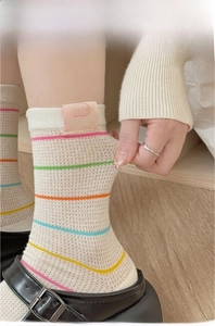 Detail of colorful striped cotton socks showing fine high-twist yarn and puppy label