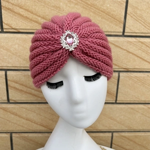 Close-up of pink knit headband with a silver crystal brooch on a mannequin