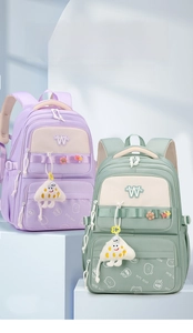 Close-up of waterproof nylon student backpacks with ergonomic straps and cartoon charms
