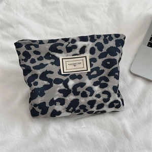 Dettaglio della borsa cosmetica leopardata con etichetta tessuta e cerniera nera