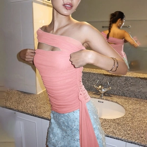 Detail of pink one-shoulder ruched top with waist cutout and blue sequined mini skirt