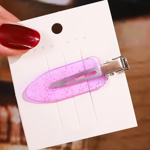 Detailansicht einer rosa Haarspange mit Goldglitzer auf einer weißen Displaykarte