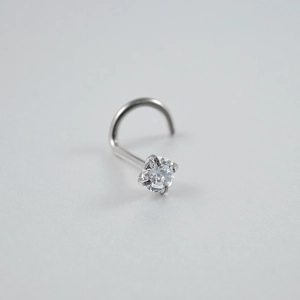 Macro shot of silver G23 titanium nose stud with round clear cubic zirconia inlay