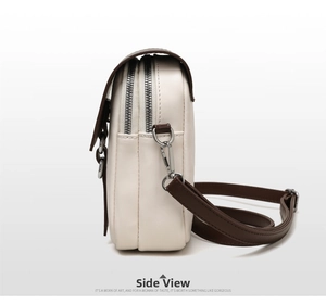 Side view of small crossbody bag featuring dual zippers and adjustable brown shoulder strap