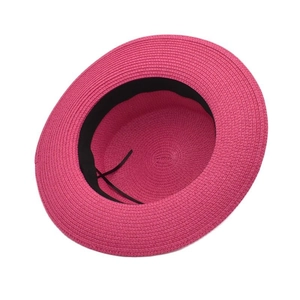 Detalle de sombrero de paja rosa fucsia con banda interior negra y cordón de ajuste suave