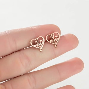 Rose gold heart-shaped earrings with musical note hollow design shown on hand