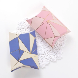 Elegant gold foil geometric pillow boxes for gifts in pink and blue colors on white lace