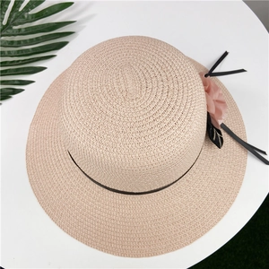 Top view of beige straw sun hat with pink chiffon flowers and black ribbon detail