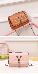 Close-up of diamond quilted PU leather bags with metal V-buckle and tassel charms