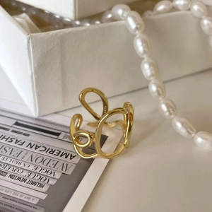 Abstract irregular S925 sterling silver gold ring displayed on fashion magazine paper