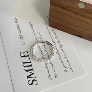 Detail view of S925 sterling silver beaded ring with white pearls on a minimalist background