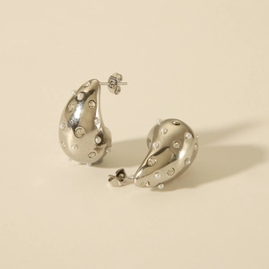 Detailed close-up of silver teardrop earrings featuring white pearls and clear zircons