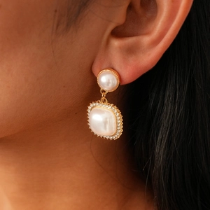 Detail of vintage pearl drop earrings with rhinestones on model showing elegant fit