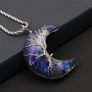 Macro detail of crescent moon pendant with blue gravel stones and wire wrapped tree of life