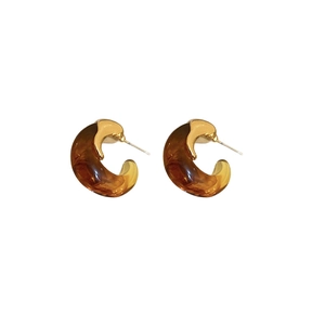 Maillard style amber C-shaped resin earrings with gold metal accents on white background