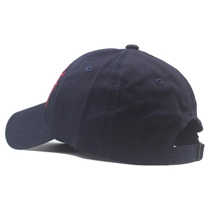 Detail view of the adjustable buckle and red embroidery on dark blue baseball cap