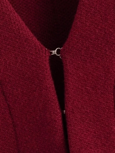 Vue macro des crochets en argent et détails du col sur vêtement en tricot bordeaux