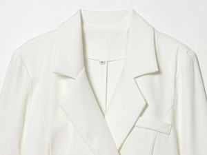 Close-up of white waist-fitted blazer dress showing woven fabric and S size label