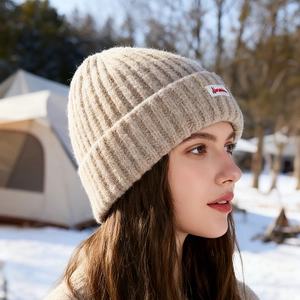 Berretto beige in maglia grossa da donna in scena invernale con protezione termica