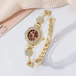 Close-up of gold quartz watch featuring a deep red dial and rhinestone-encrusted flower band