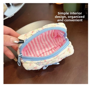 Internal view of a mini floral quilted cotton makeup bag with striped lining and zipper