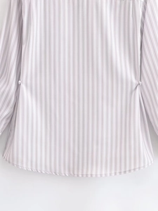 Detailed view of striped shirt side buckle and purple vertical stripe fabric texture