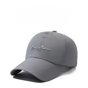 Detailed close-up of dark grey quick-dry baseball cap with white letter embroidery